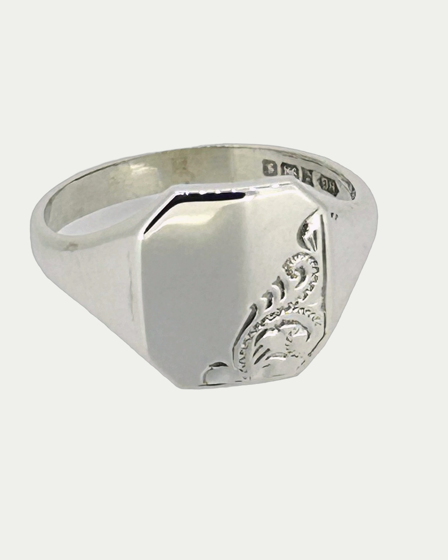 Silver signet ring with engraved shoulder detail, Polished silver signet ring with a raised rectangular face.