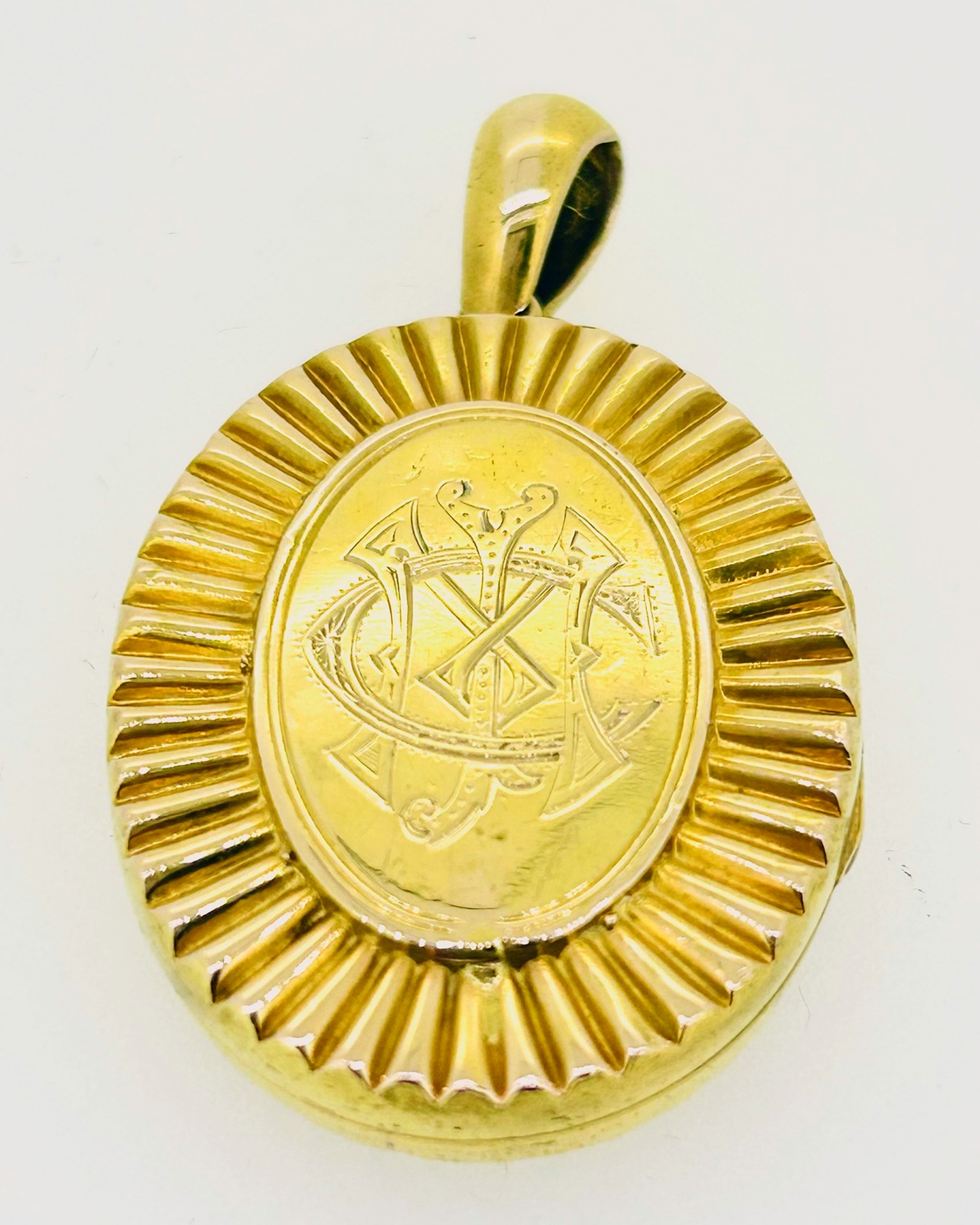18-carat Yellow Gold Large Monogrammed Locket, Large oval locket with engraved monogram and ridged border. Weight: 8.8 g.