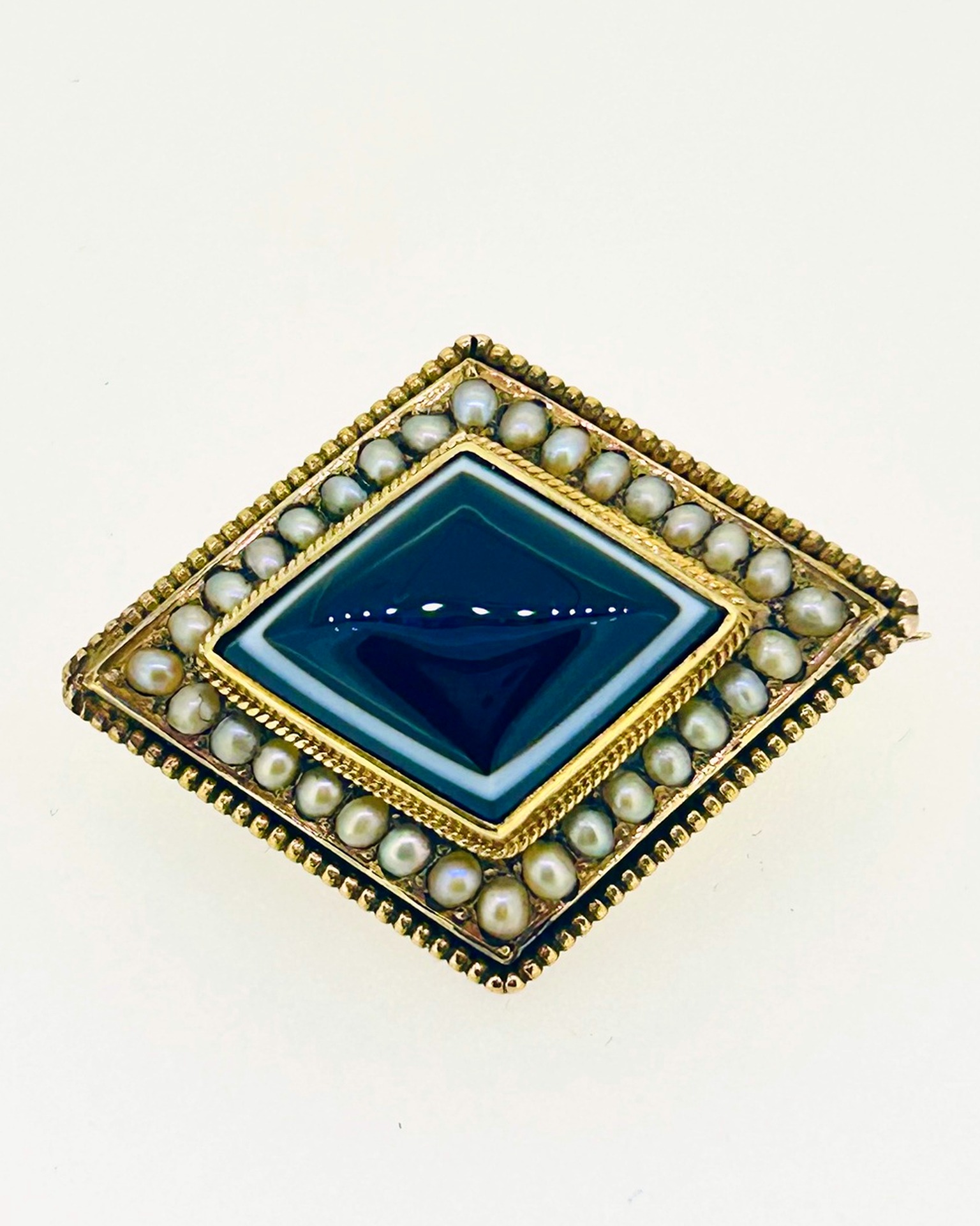 Banded agate and pearl diamond brooch, A diamond-shaped brooch with banded agate and pearl border.