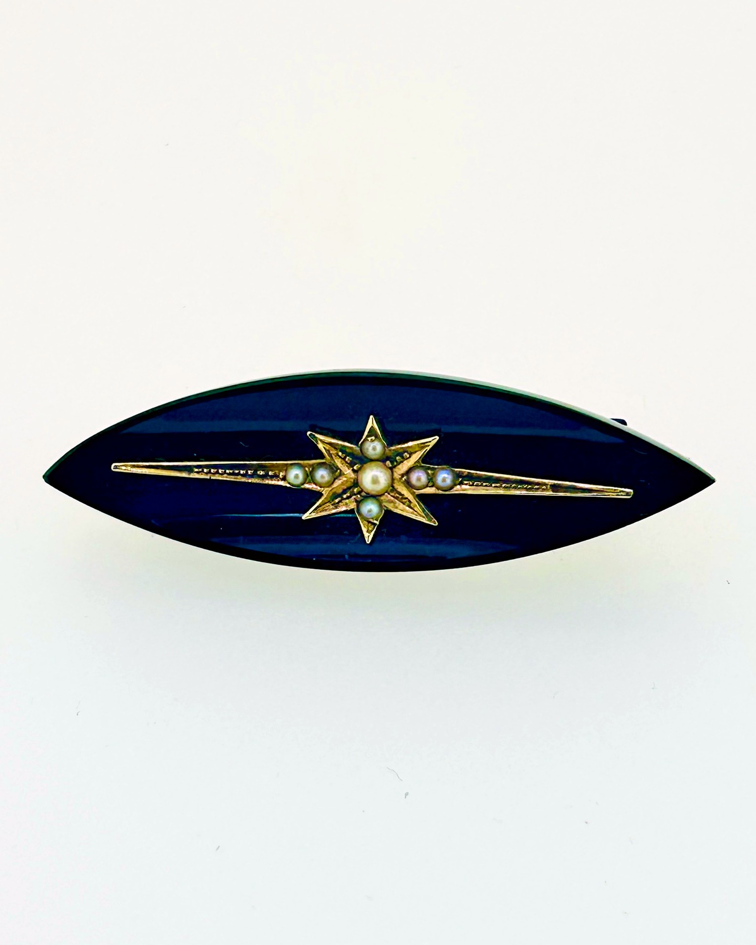 Onyx and Pearl Starburst Brooch in 9-carat Yellow Gold, A dramatic elongated onyx brooch with a central pearl starburst.