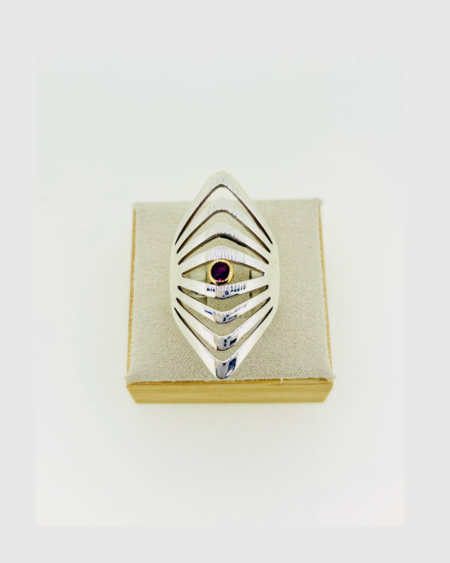 Silver Ring with Ruby in 18-carat Yellow Gold Setting, Bold chevron-style silver ring with a ruby accent.