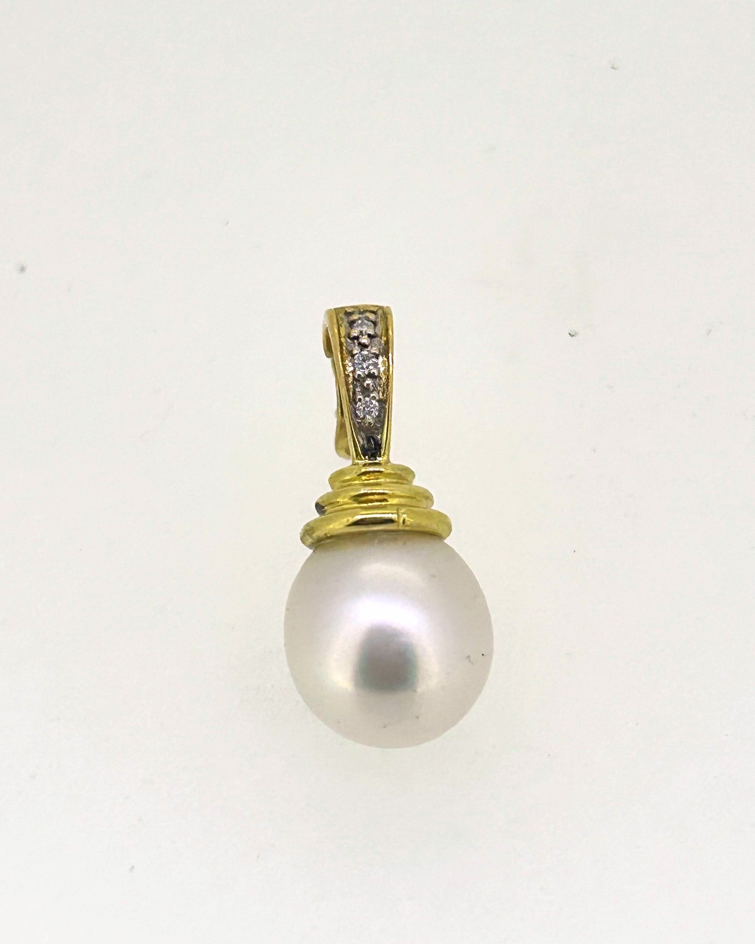 18-carat Yellow Gold Diamond and Pearl Pendant, A yellow gold enhancer set with diamond and pearl.