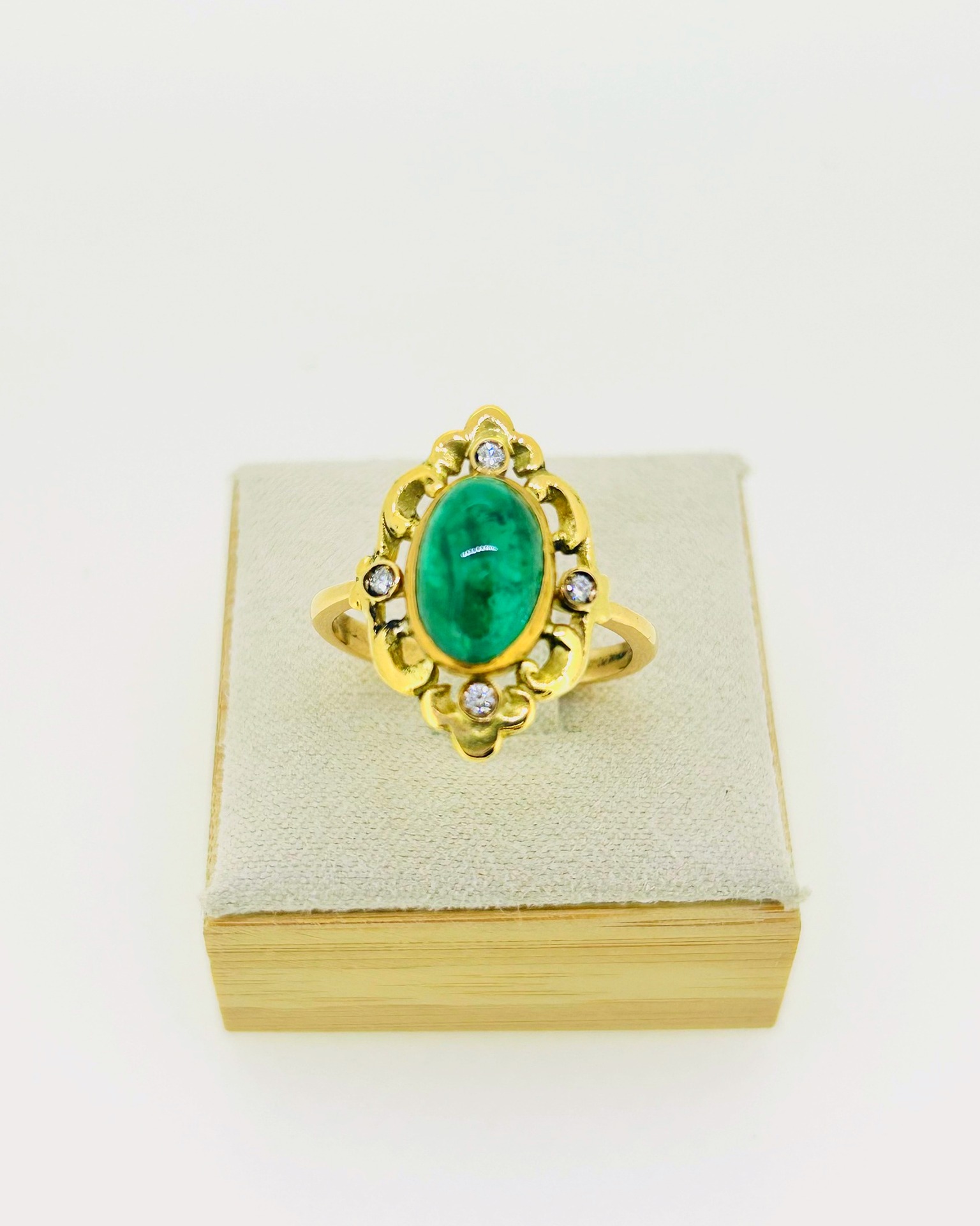 18-carat Yellow Gold Emerald and Diamond Ring, An oval emerald ring with diamond accents.