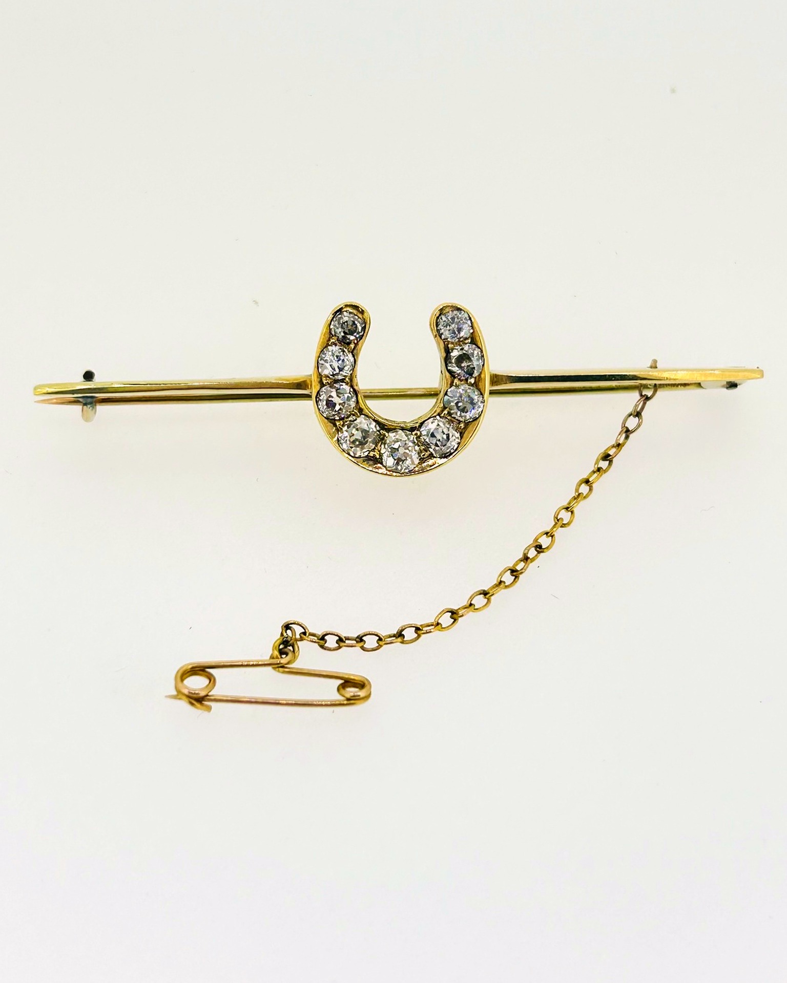 18-carat Yellow Gold Diamond Horseshoe Bar Brooch, Diamond-set horseshoe bar brooch in yellow gold. Weight: 6 g.