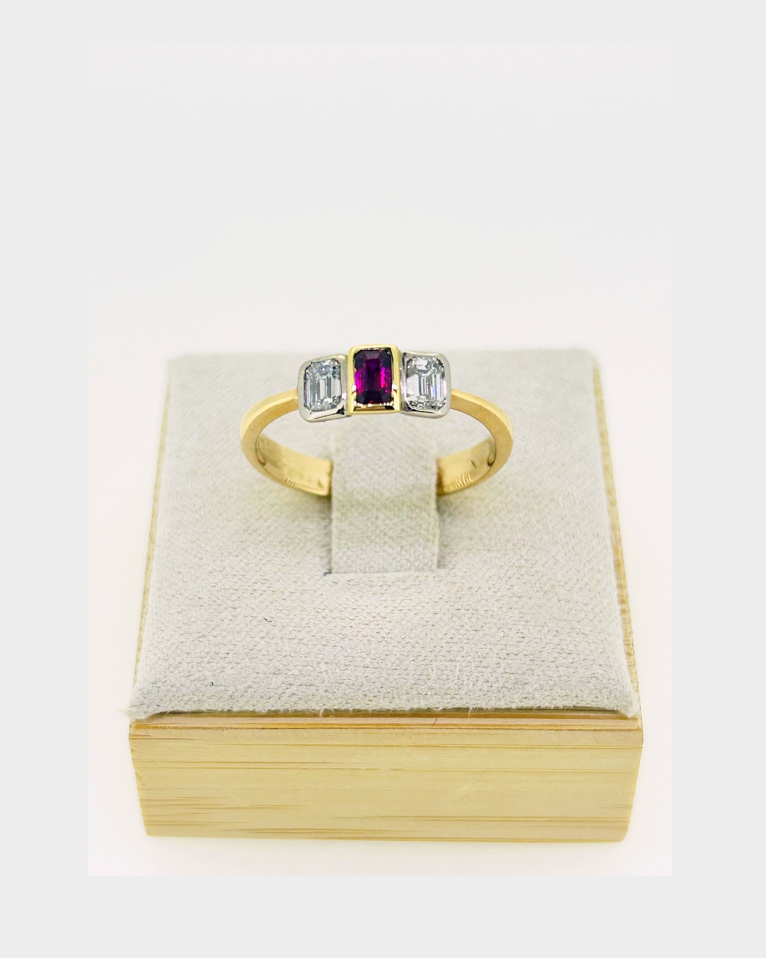 18-carat Yellow and White Gold Ruby Diamond Ring, Set with a ruby and diamonds in a modern three-stone design.