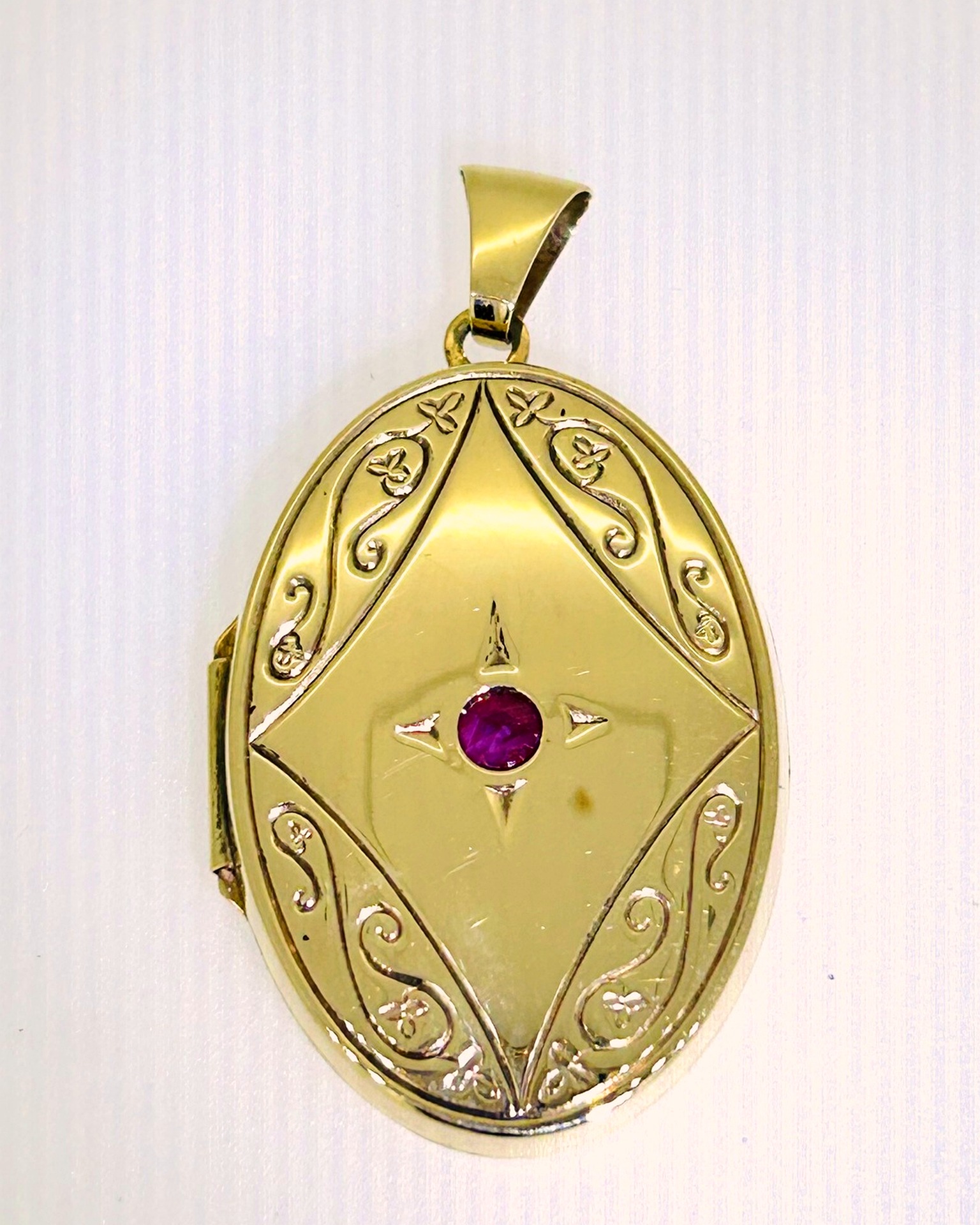 9-carat Yellow Gold engraved locket with synthetic ruby, Weight: 4.4 g.