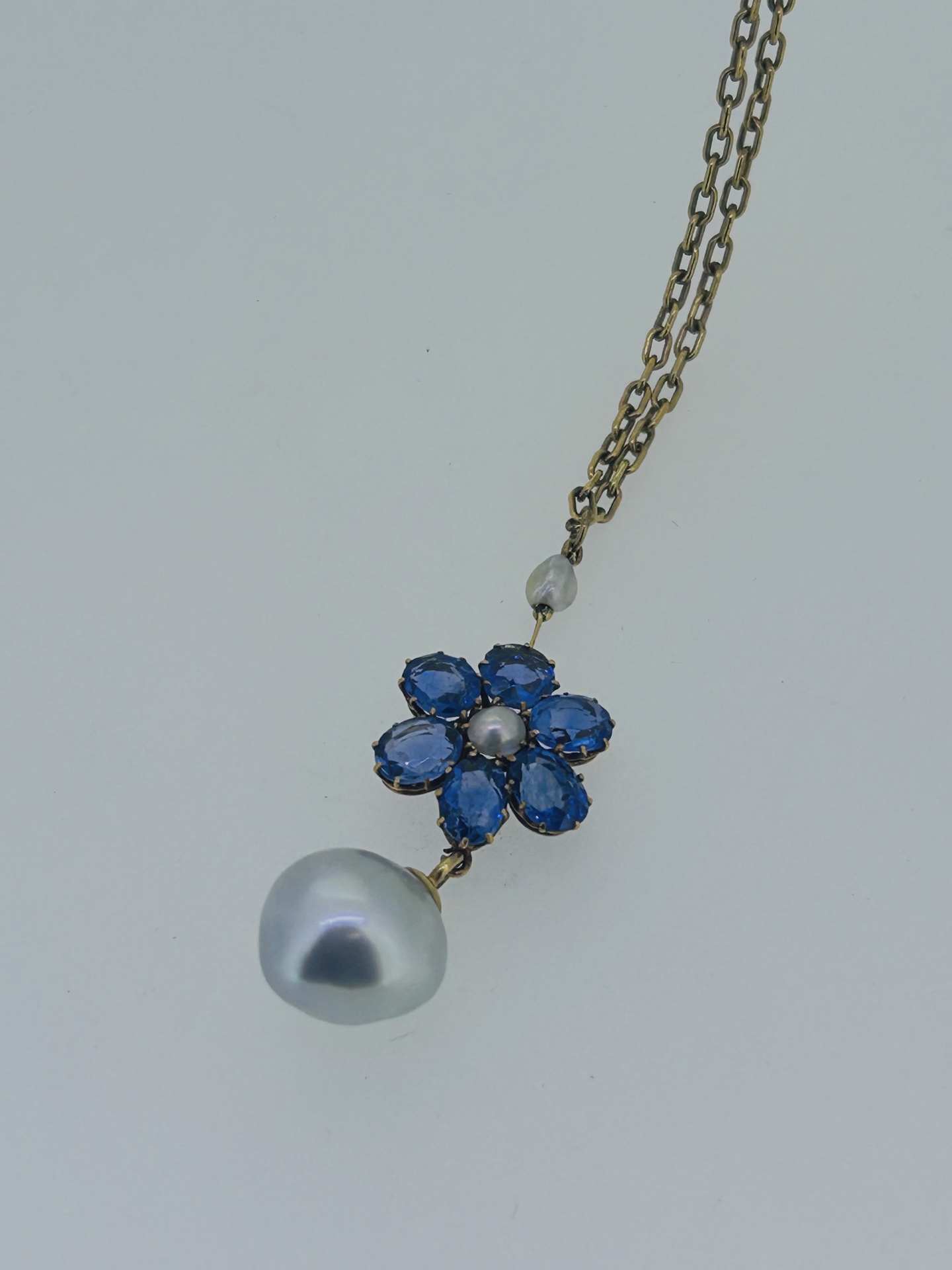 Antique 14-carat Yellow Gold Sapphire & Pearl Flower Pendant, Sapphire flower pendant on a chain with pearl drop accent.