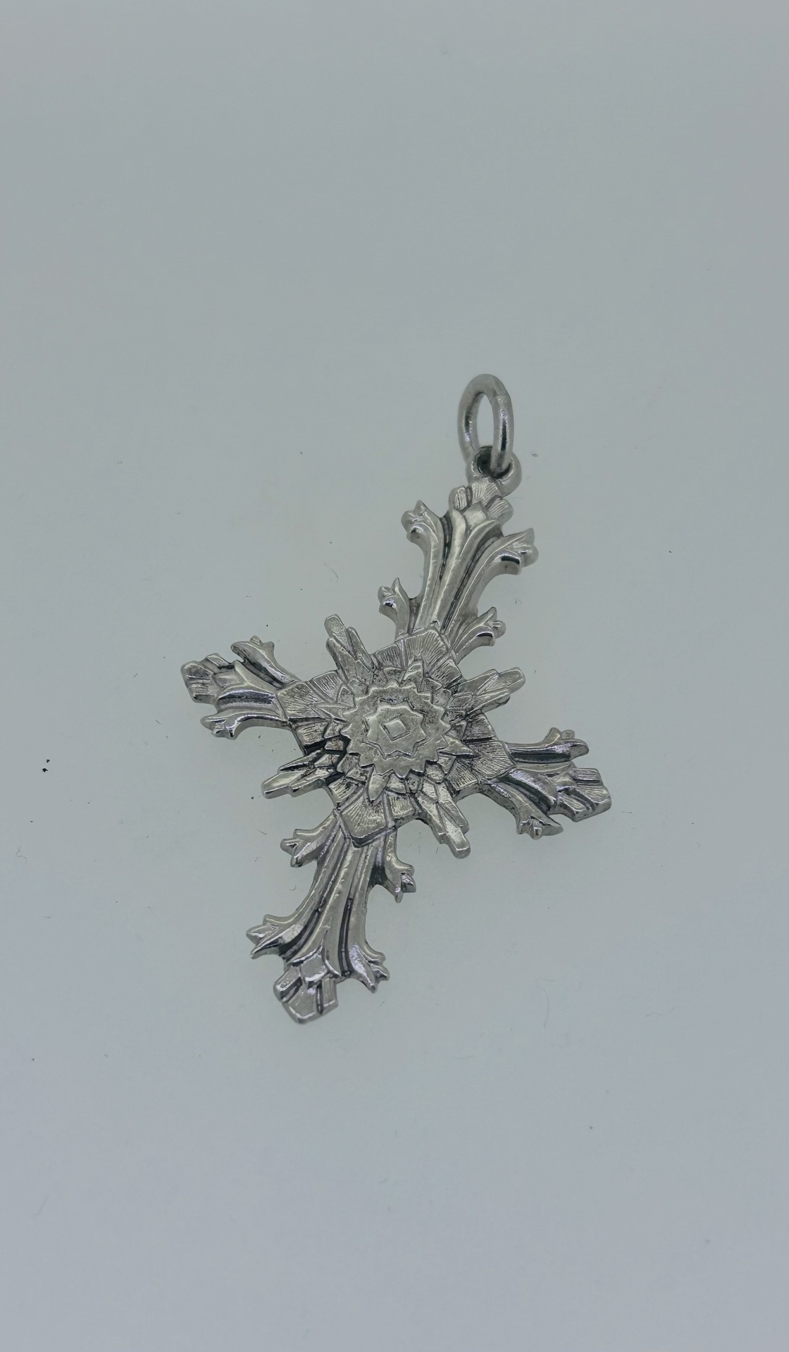 Silver ornate cross pendant, Decorative cross pendant with an ornate floral design.