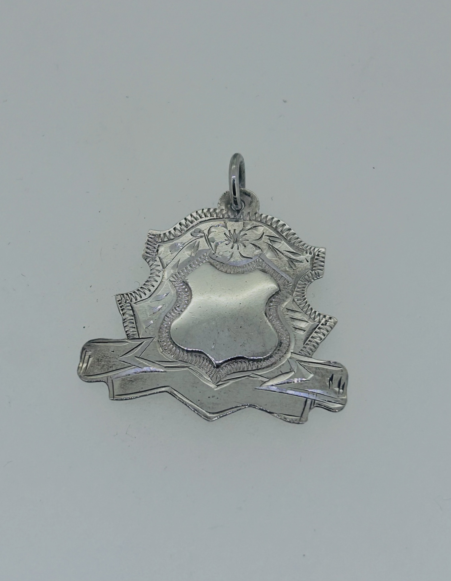 Silver vintage medal pendant, A silver vintage medal pendant with engraved floral details.