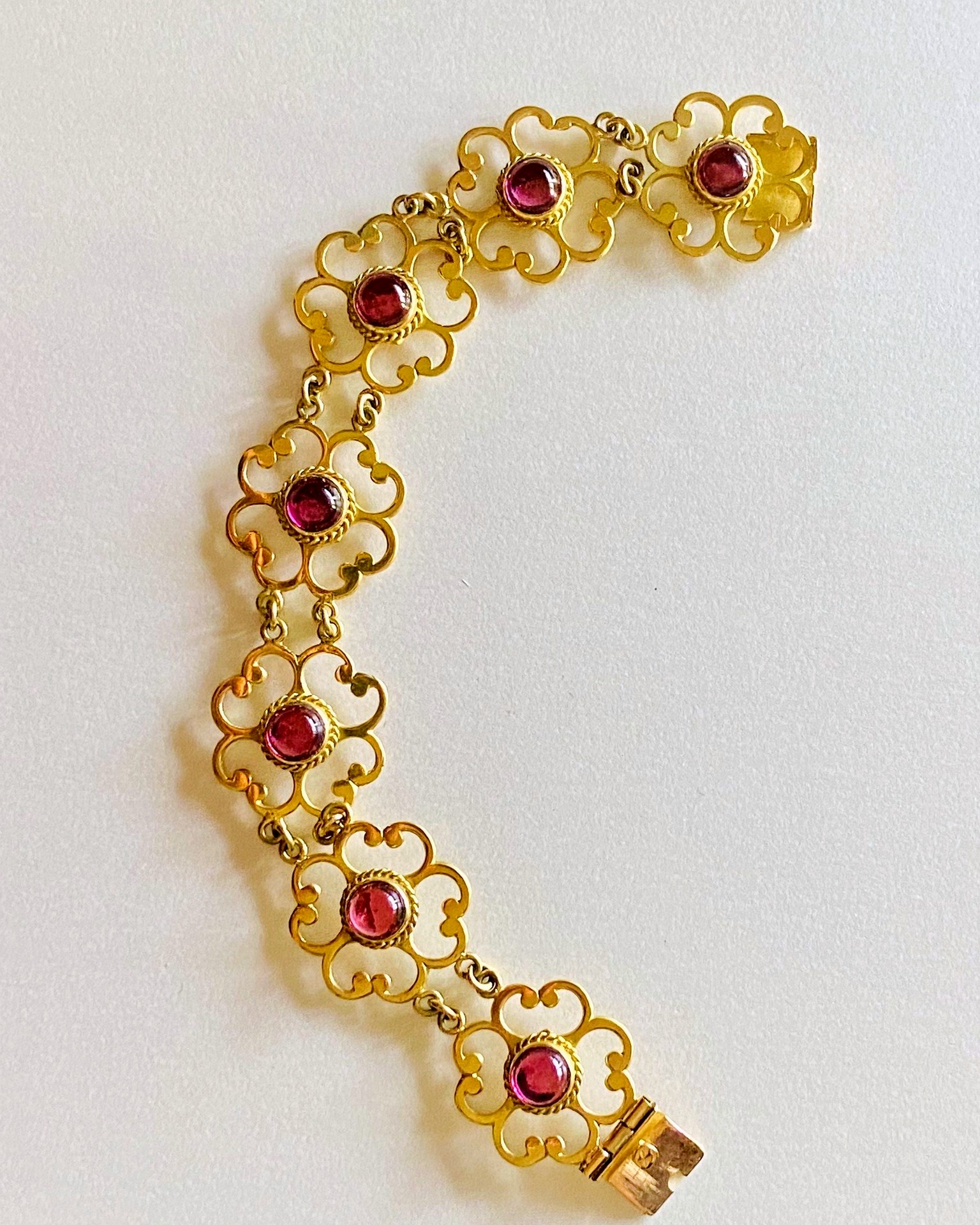 18-carat Yellow Gold Rhodolite Garnet Bracelet, Decorative openwork bracelet with rhodolite garnet cabochons.