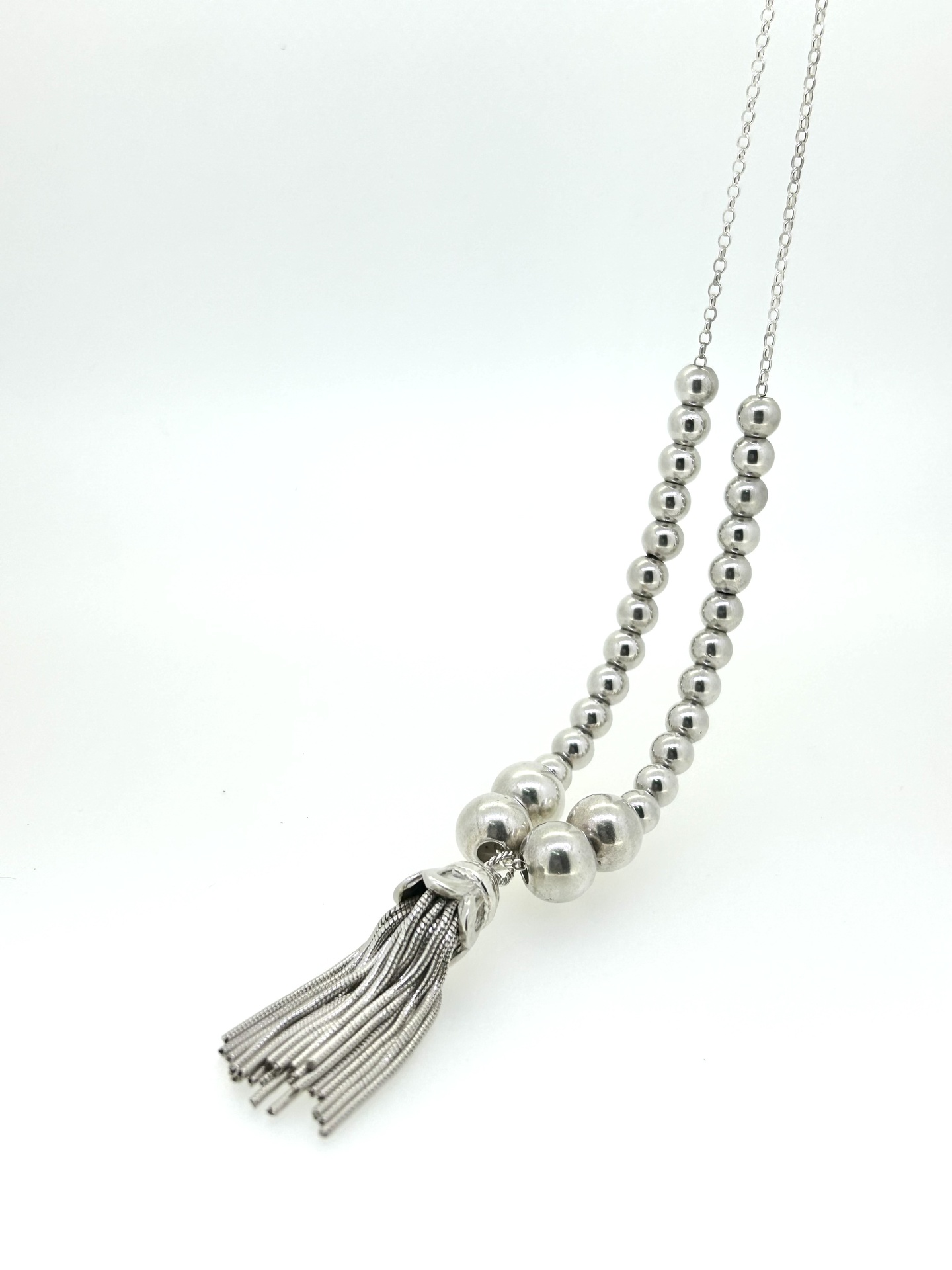 Graduated ball tassel necklace, A graduated ball necklace with tassel pendant.